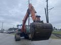 A 2006 Hitachi ZX200LC excavator with a large bucket raised high, showcasing its hydraulic arm and track chassis designed for digging and construction activities