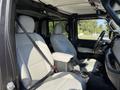Interior of a 2021 Jeep Gladiator showing two front seats with light gray upholstery and a center console