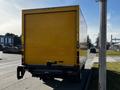 A yellow 2017 Hino 155 truck seen from the rear with a large box-shaped cargo area and visible tail lights