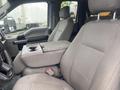 Interior of a 2017 Ford F-550 featuring two front seats with fabric upholstery and a console between them