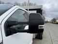 Close-up of the side mirror of a white 2021 Ford F600 with a black cover showing a slight reflection of the surroundings