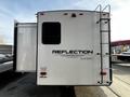 A white 2021 Grand Design Recreational 311BHS trailer featuring a ladder on the side and the word "REFLECTION" prominently displayed on the rear