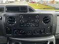 Dashboard of a 2011 Ford Econoline featuring audio controls air conditioning knobs and multiple circular air vents