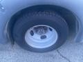 A close-up of a tire and wheel of a 2017 Chevrolet Express showing a silver wheel rim and a black tire