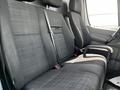 Interior seating of a 2017 Mercedes-Benz Sprinter featuring two fabric-covered front seats with a center console and seat belts