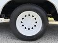 A close-up of a white wheel from a 2016 Ford Transit featuring a circular rim with multiple ventilation holes and a black tire with tread patterns
