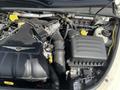 Close-up of the engine compartment of a 2005 Chrysler PT Cruiser featuring a turbocharged 2.4L engine with various hoses and components visible