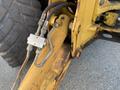 A close-up view of a hydraulic arm and connections on a yellow 2007 Komatsu WB156PS-5 construction machine
