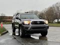 Gray 2015 Toyota Tacoma with a black grille and four-wheel drive parked on wet pavement