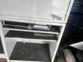 A white 2009 Ford Econoline vehicle with a storage compartment featuring shelves and an electronic device inside