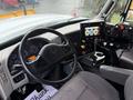 The interior of a 2016 International 7400 truck featuring a steering wheel dashboard with gauges and controls for various functions and a touchscreen display mounted on the center console
