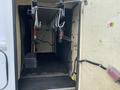 A 2015 Ford F-550 with an open storage compartment featuring metal shelving and various equipment attached inside the walls
