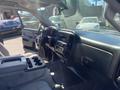 Interior view of a 2014 GMC Sierra 1500 showcasing the dashboard center console and front seats with controls and storage compartments visible