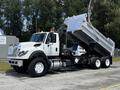 A 2017 International WorkStar 7600 dump truck with a white exterior and raised dumping bed showing the hydraulic lift mechanism