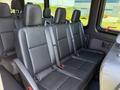 Interior view of a 2023 Mercedes-Benz Sprinter showing black leather seats with seatbelts and armrests