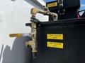 A close-up of a tank with metal valves labeled foam isolation valve and tank isolation valve connected to a 2009 Ford F-550