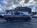 A gray 2017 RAM 1500 pickup truck with black wheels and chrome accents parked sideways