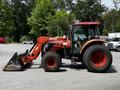 A 2011 Kubota M8540D tractor with a front loader attachment and large tires is parked with its cabin to the side