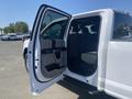 A white 2017 Ford F-150 with an open rear door revealing a spacious interior with gray seating