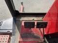 Interior controls of a 2014 Toro Groundmaster 5910 featuring two black levers on a red panel with wear and a textured floor surface