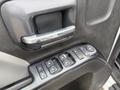 Close-up of the door panel of a 2016 GMC Sierra 1500 featuring the door handle and control buttons for windows and mirrors