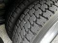 Close-up of a heavy-duty tire showing a rugged tread pattern designed for traction and durability on a 2014 Hino 195 vehicle