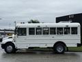 A white 2016 International CE300 school bus with blue lights on top and windows displaying information about its use