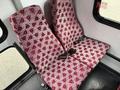 Two red and white patterned seats in a 2015 Ford Econoline van showing a repetitive design with the letter A