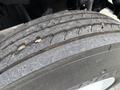 Close-up of a worn tire from a 2005 Freightliner M2 106 showing visible tread wear and debris embedded in the rubber