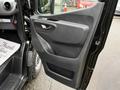 A 2022 Mercedes-Benz Sprinter driver side door panel featuring a handle and storage compartment