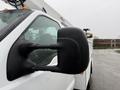 A side view mirror of a 2006 Ford F-450 with water droplets on it