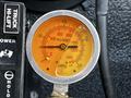 A close-up of a pressure gauge with an orange dial indicating measurements in psi and kPa on a 2017 International WorkStar 7600 truck