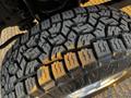 Close-up of a rugged tire tread from a 2012 Ford F-250 showcasing deep grooves and a robust design for off-road performance