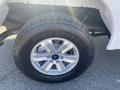 Close-up of a silver wheel and tire from a 2019 Ford F-150 featuring an Open Country tire design and five silver spokes