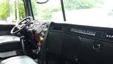 Interior view of a 2019 Western Star Trucks 4900 showing the dashboard steering wheel and gear shift with a black and wood panel finish