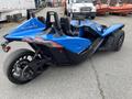 A blue 2020 Polaris Slingshot with three wheels and a sleek, aerodynamic design featuring two seats and a distinctive front end