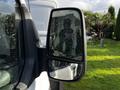 A 2020 Ford Transit side mirror reflecting water droplets and the interior of the vehicle