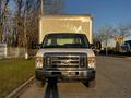 A 2017 Ford Econoline van with a large box cargo area at the rear, facing directly towards the viewer with a shiny front grille and headlights