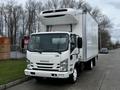A white 2018 Isuzu NRR box truck with a refrigeration unit on top parked on a street