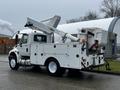 A 2013 International DuraStar bucket truck with a white body and an elevated boom arm attached to the rear designed for utility work