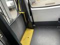 Interior view of a 2018 Chevrolet Express showing the floor and wall space with yellow and gray surfaces and a handrail on the side