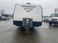 Front view of a 2015 Winnebago of Indiana travel trailer with a prominent logo on the side and a hitch attachment visible at the front