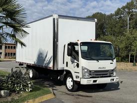 A white 2019 Isuzu NQR box truck with a large cargo area and a clean, modern design parked at an angle