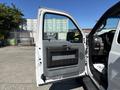 A 2016 Ford F-550 with an open driver's side door revealing the interior features and panel of the truck