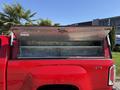 A 2018 GMC Canyon with an open truck bed cover revealing a silver metal interior space