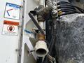 A close-up of a 2012 International DuraStar 4300's hydraulic fittings with visible rust and connected hoses