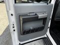 Interior door panel of a 2016 Ford F-550 featuring a gray handle and storage compartment