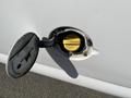 A close-up of a fuel filler cap on a 2013 Chevrolet Express showing a yellow label indicating fuel type and instructions for use