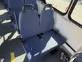 A blue upholstered bus seat with a safety strap is shown in the interior of a 2017 Chevrolet Express