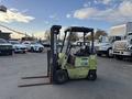 A 2000 Clark GPS 15 forklift with a green exterior and two long forks positioned in the front
